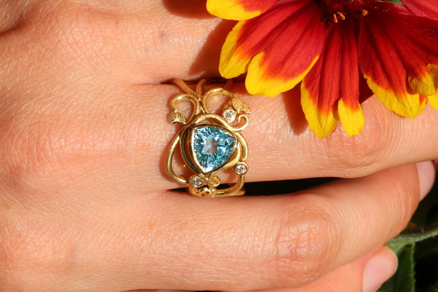 Gold ring with topaz stones and diamonds. Vines and tendrils.