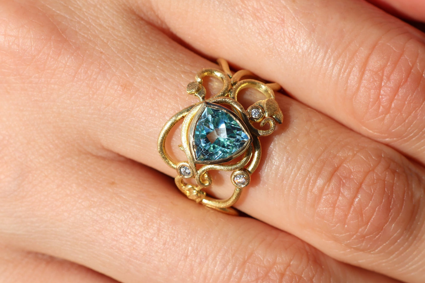 Gold ring with topaz stones and diamonds. Vines and tendrils.