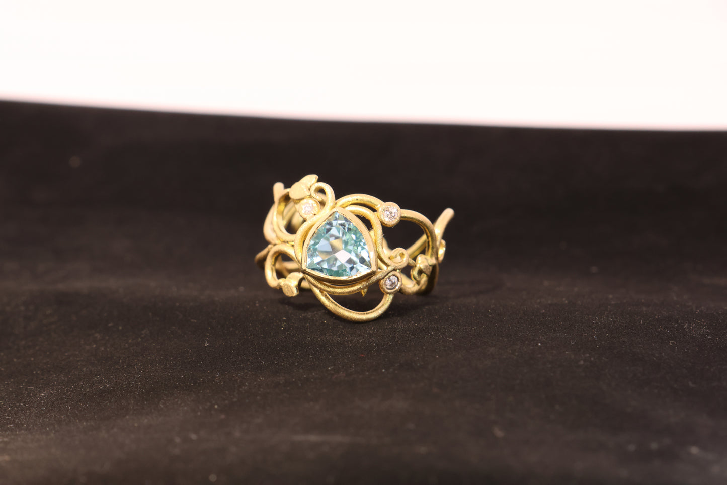 Gold ring with topaz stones and diamonds. Vines and tendrils.